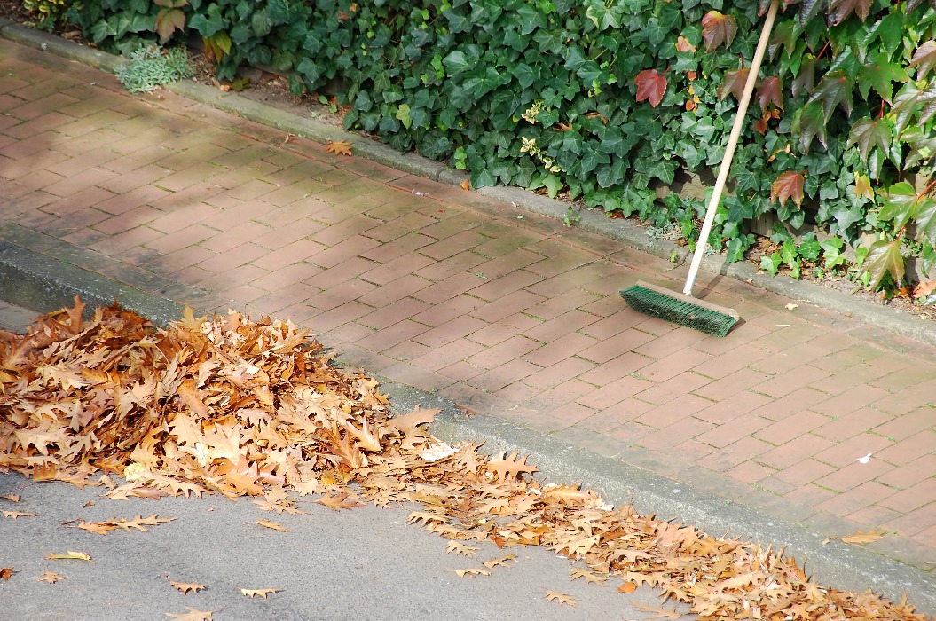 Gehweg Fegen im Herbst