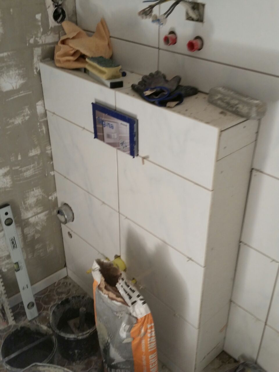 Baustelle im Badezimmer mit frisch verfliester Vorwand und Werkzeugen