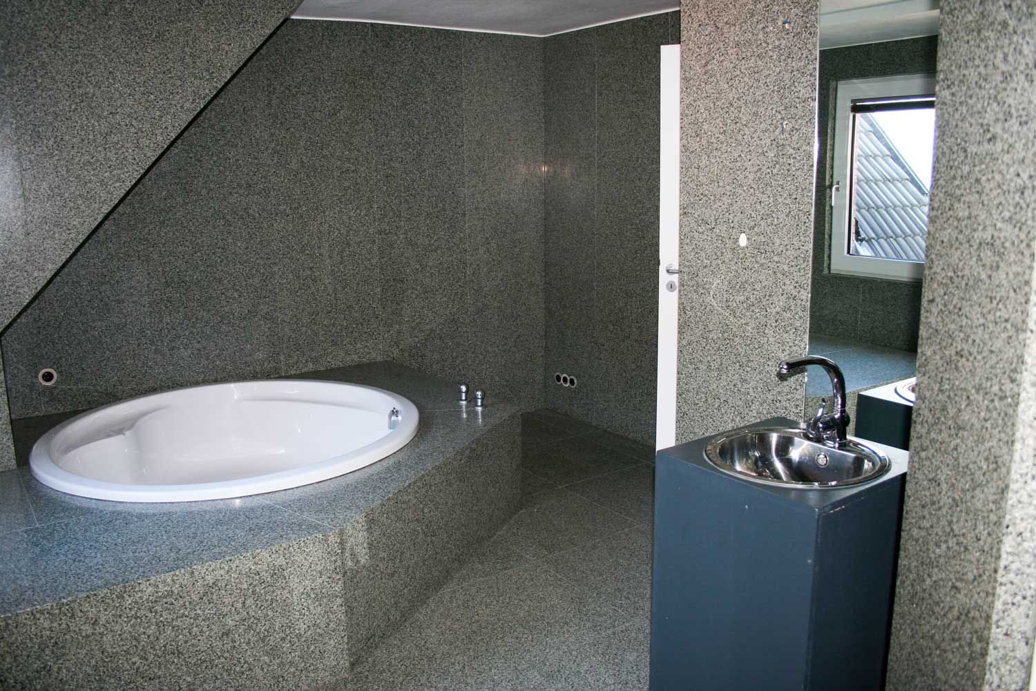 Modernes graues Badezimmer mit ovaler Badewanne und Edelstahlwaschbecken